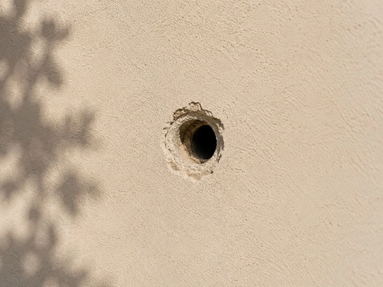 Close-up example of a hole in stucco